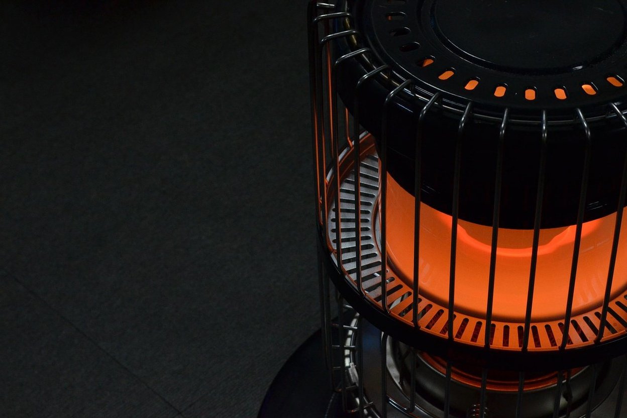 A glowing orange space heater with a black protective cage.