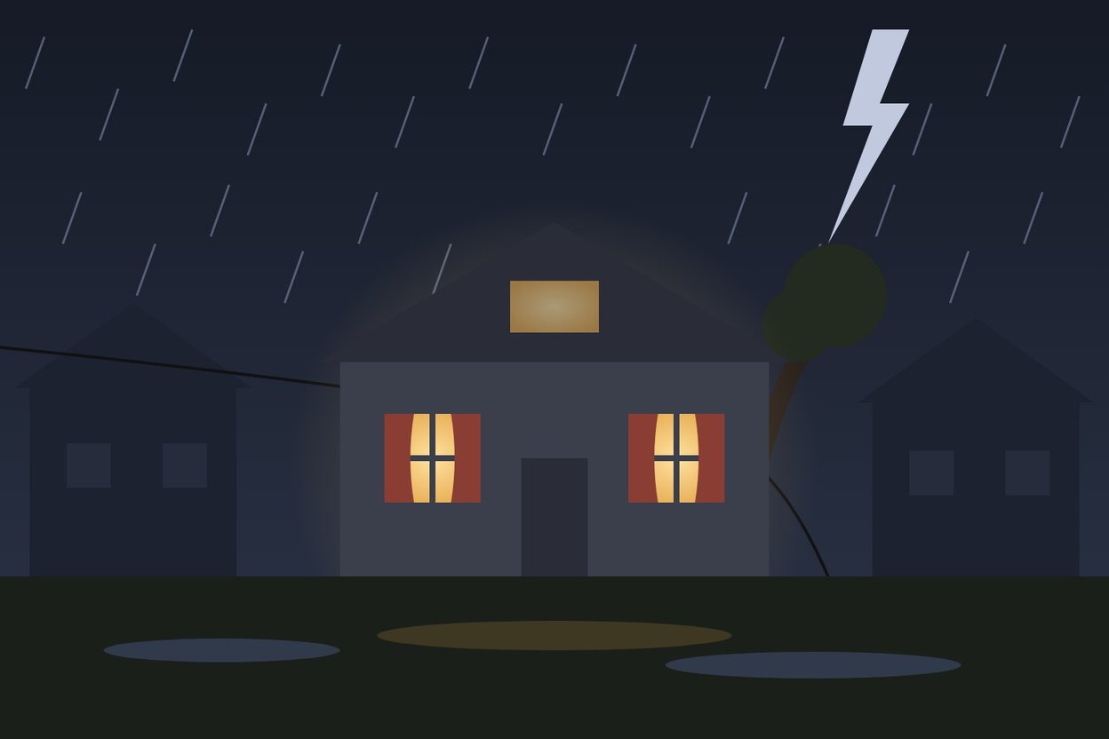 A lit window of a house at night during a storm
